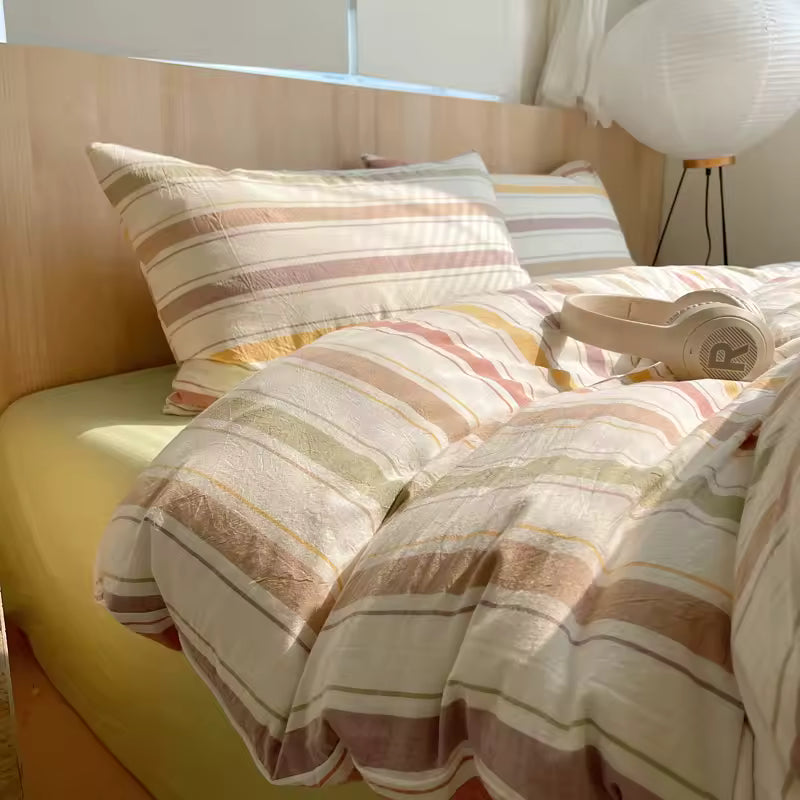 Striped bedding on a bed with pillows in a bright room