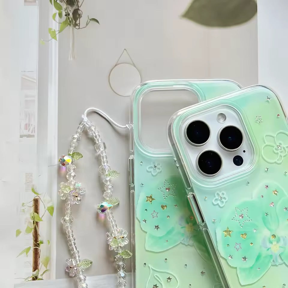 Green phone case with floral design and decorative chain on a light background