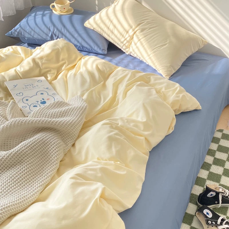 Cozy aesthetic bedding with pastel cream duvet and blue fitted sheet for modern minimalism.