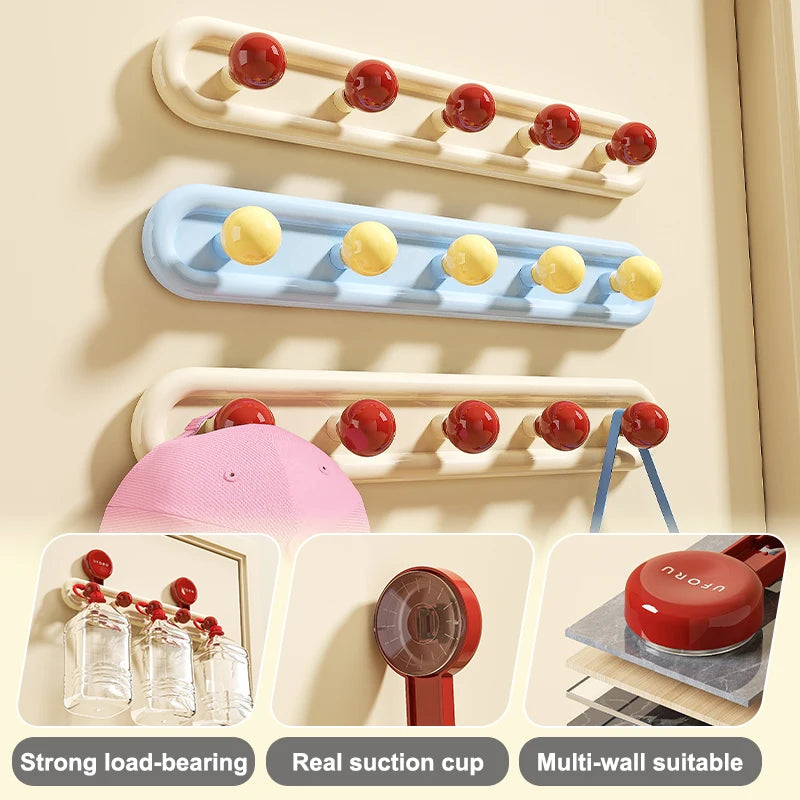 Blue suction cup wall hooks shown with round yellow mounts, pink cap, and blue handbag.