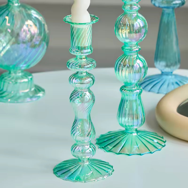 Green glass candle holders on a white surface