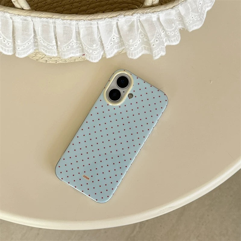 Phone case with polka dot pattern on a beige surface