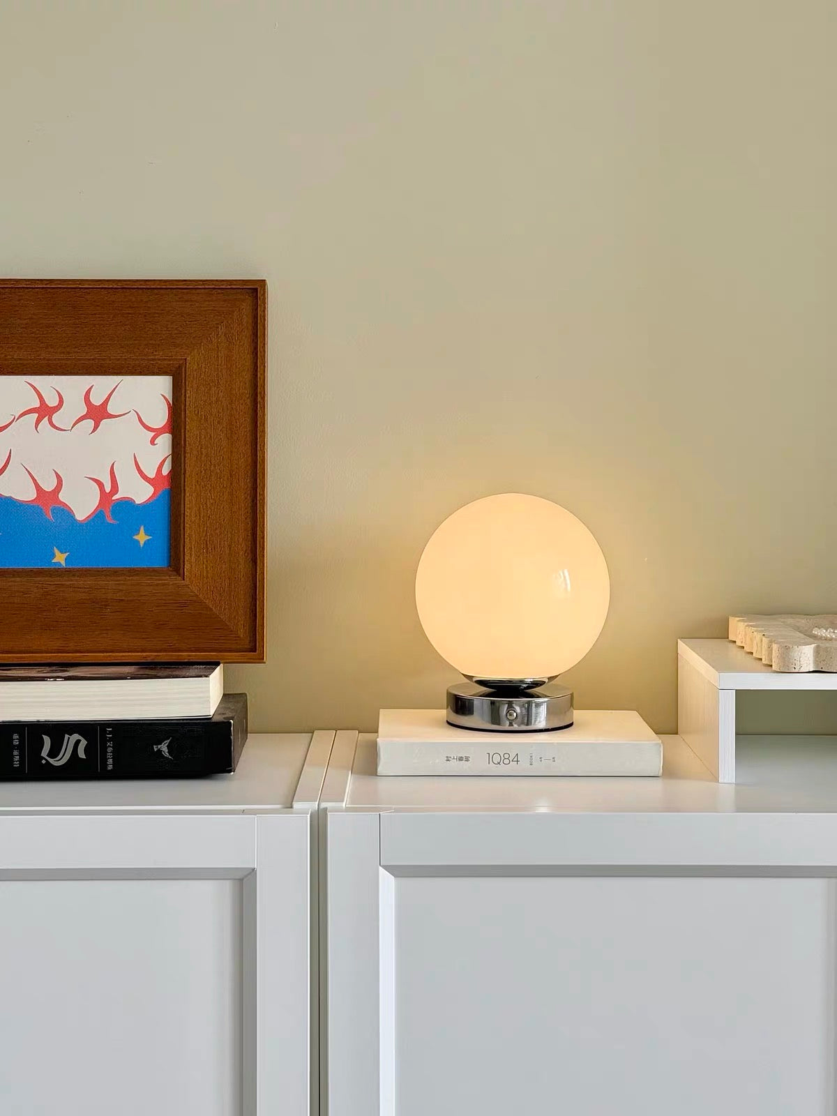Table lamp on a surface with a framed artwork in the background