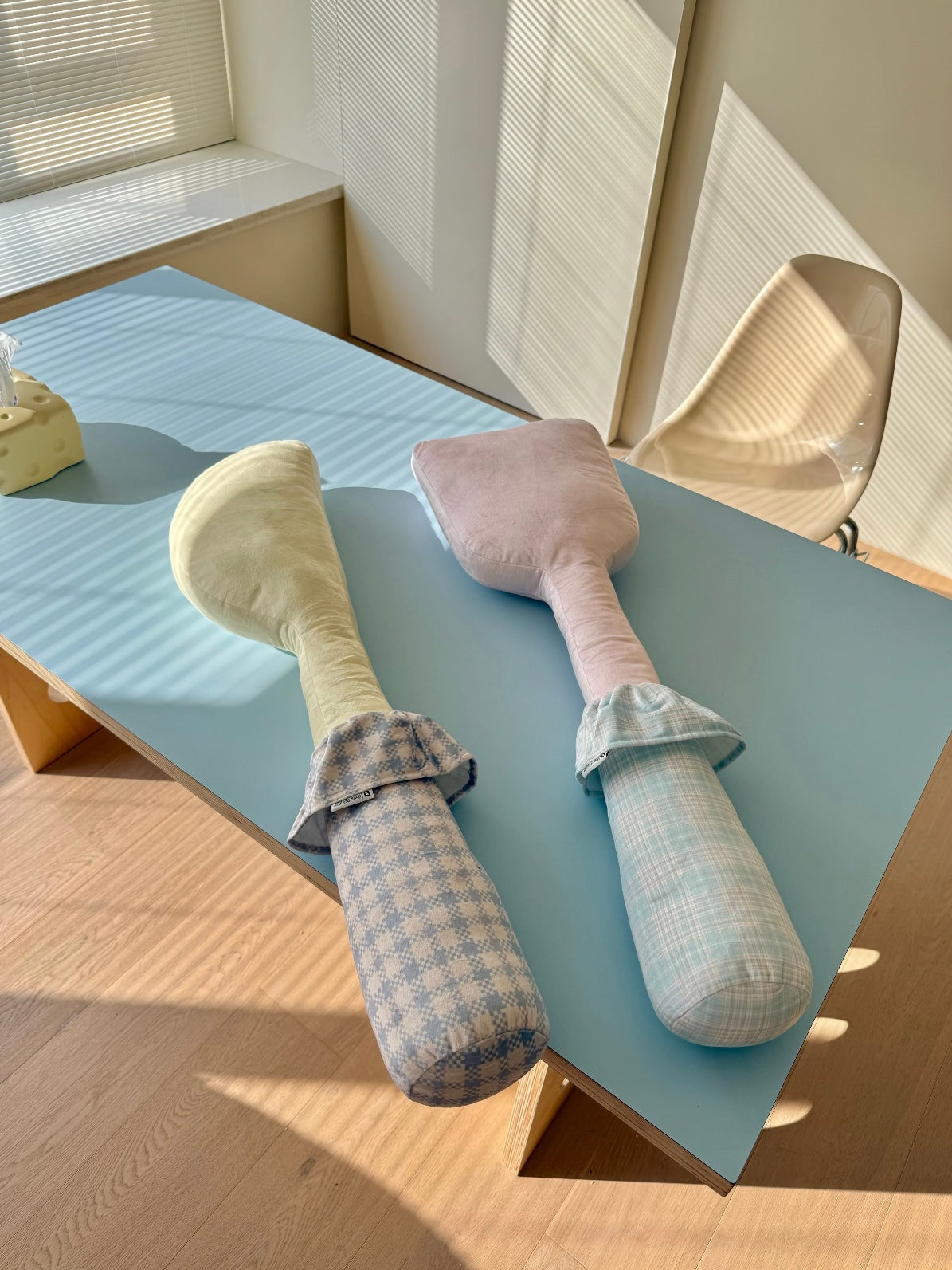 A yellow knife and pink spatula utensil pillow pair has checkered handles and gathered fabric collars.