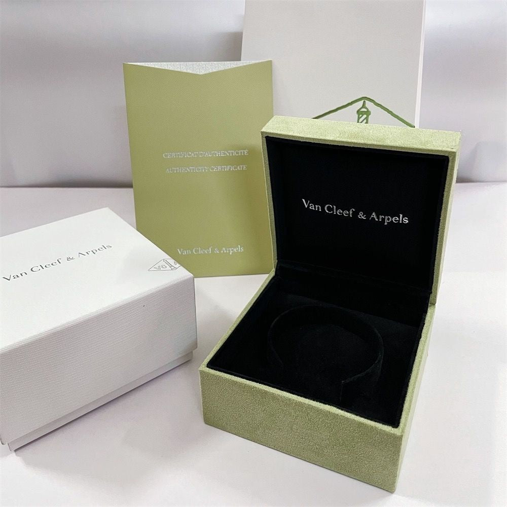 Jewelry box with luxury bracelet set inside, including a certificate and green gift bag