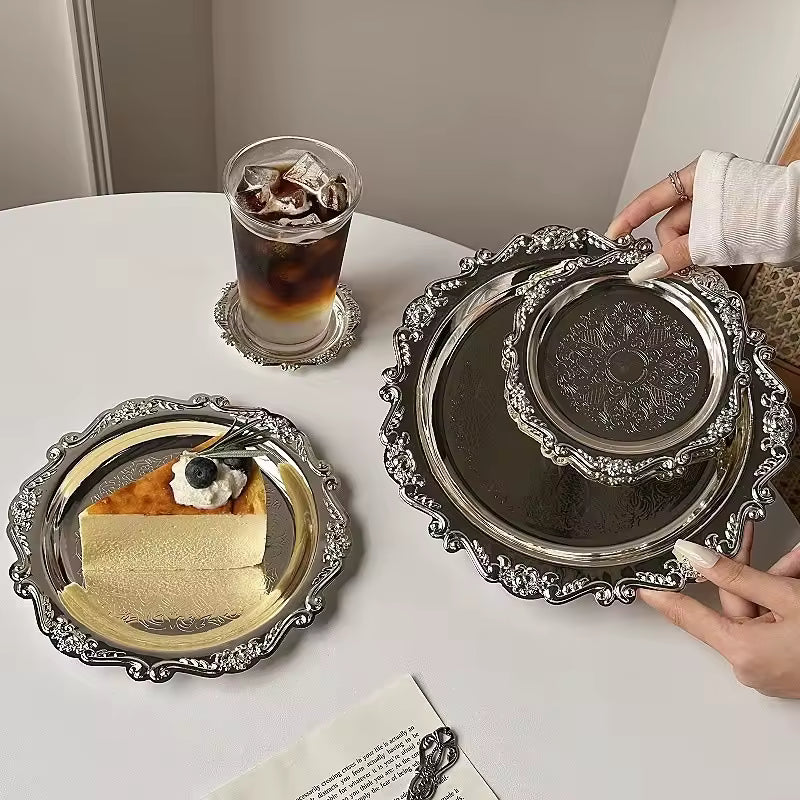 Slice of cheesecake with a glass of iced coffee on a decorative silver tray.