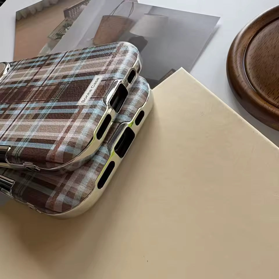 Plaid patterned phone case on a beige surface with a blurred background