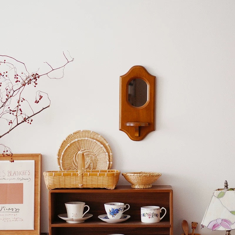 Elegant wooden mirror with curved top and decorative edge.