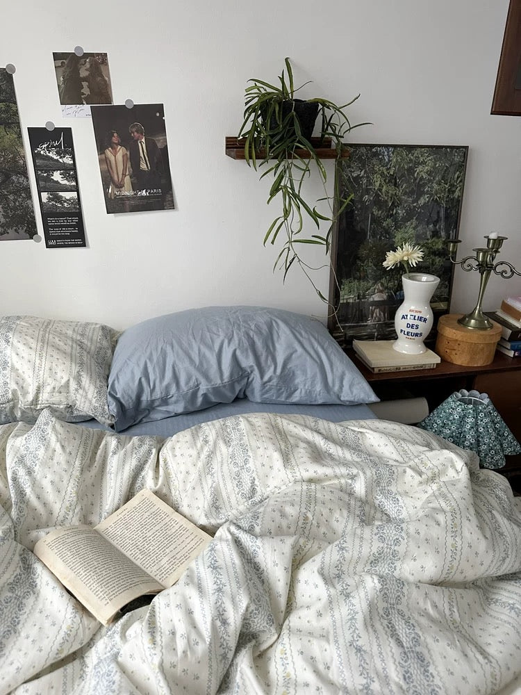 Neutral floral duvet cover layered with soft blue sheets creating timeless cottage inspired interior for everyday relaxation.