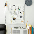 Wall-mounted storage rack with adjustable shelves and hooks. Stylish organizer for cosmetics and decorative supplies.