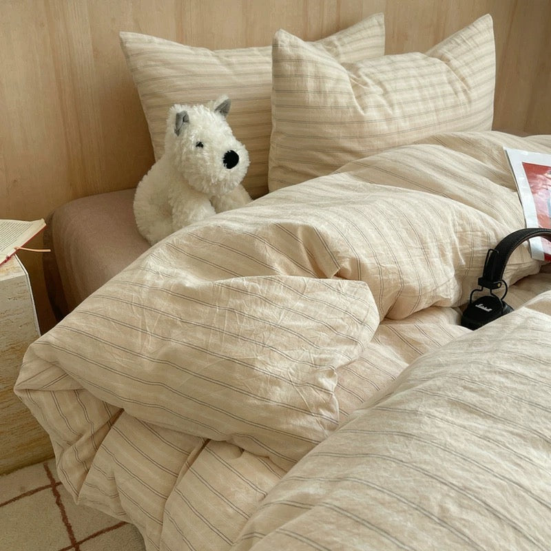 Beige comforter on a bed with pillows and a magazine titled 'Here's to Another Year'.