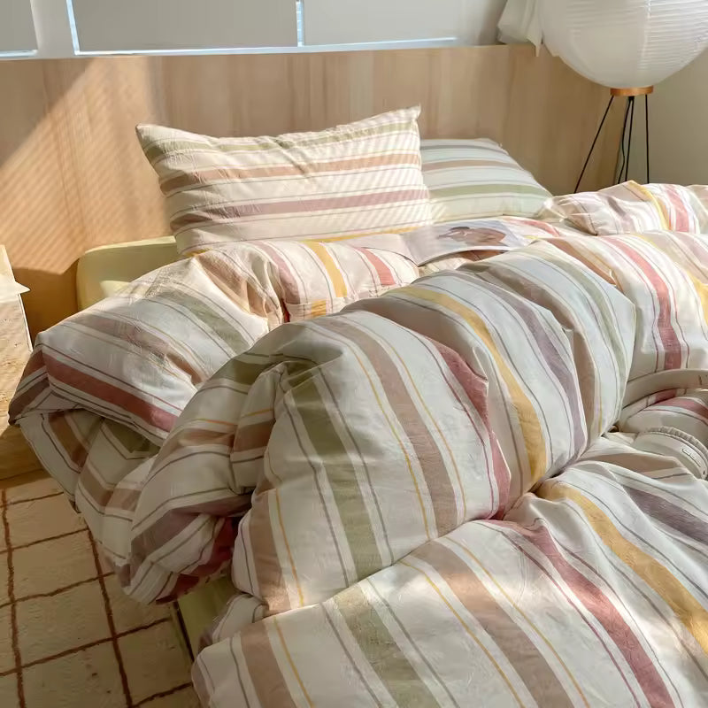 Striped bedding on a bed with pillows in a bright room