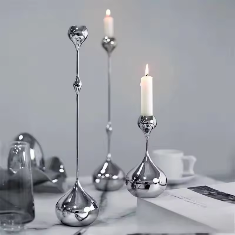 Silver candle holders with candles on a table setting