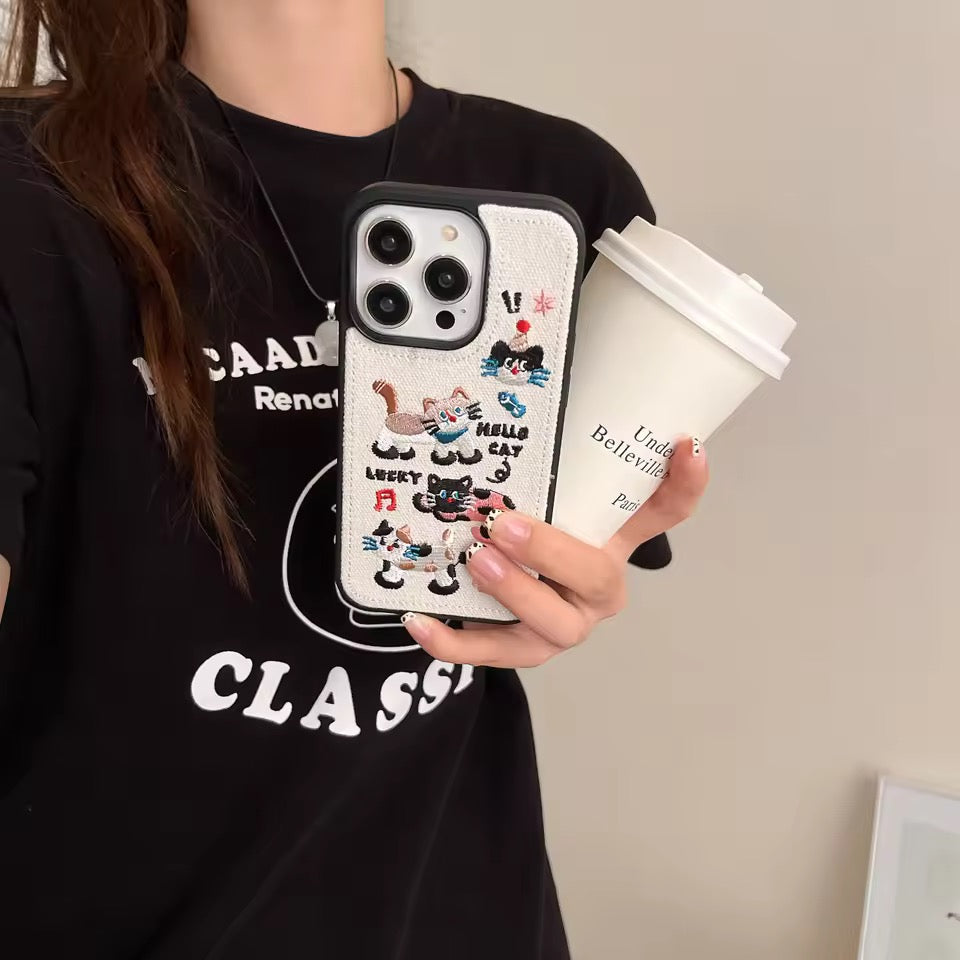 Person holding a phone with a cartoon case and a coffee cup.