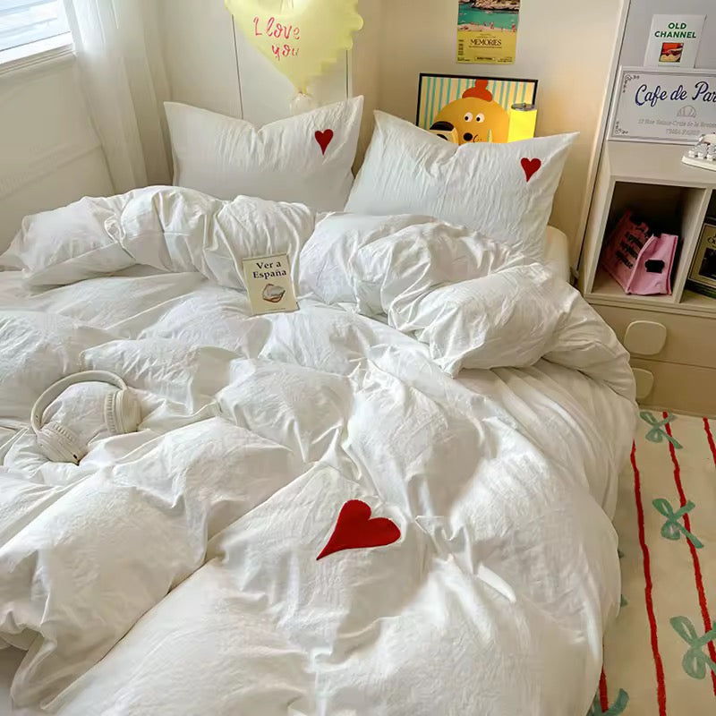White heart embroidered duvet cover set displayed on a cozy bed with pastel decor