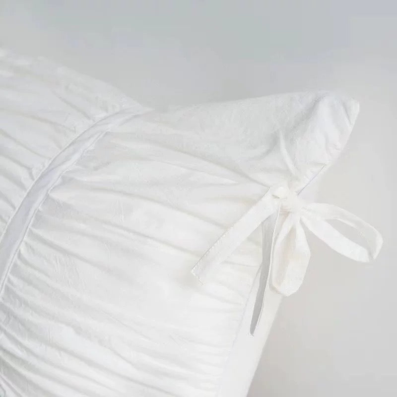 Coquette pleated cotton pillowcase styled with ribbon ties for a romantic aesthetic vibe.