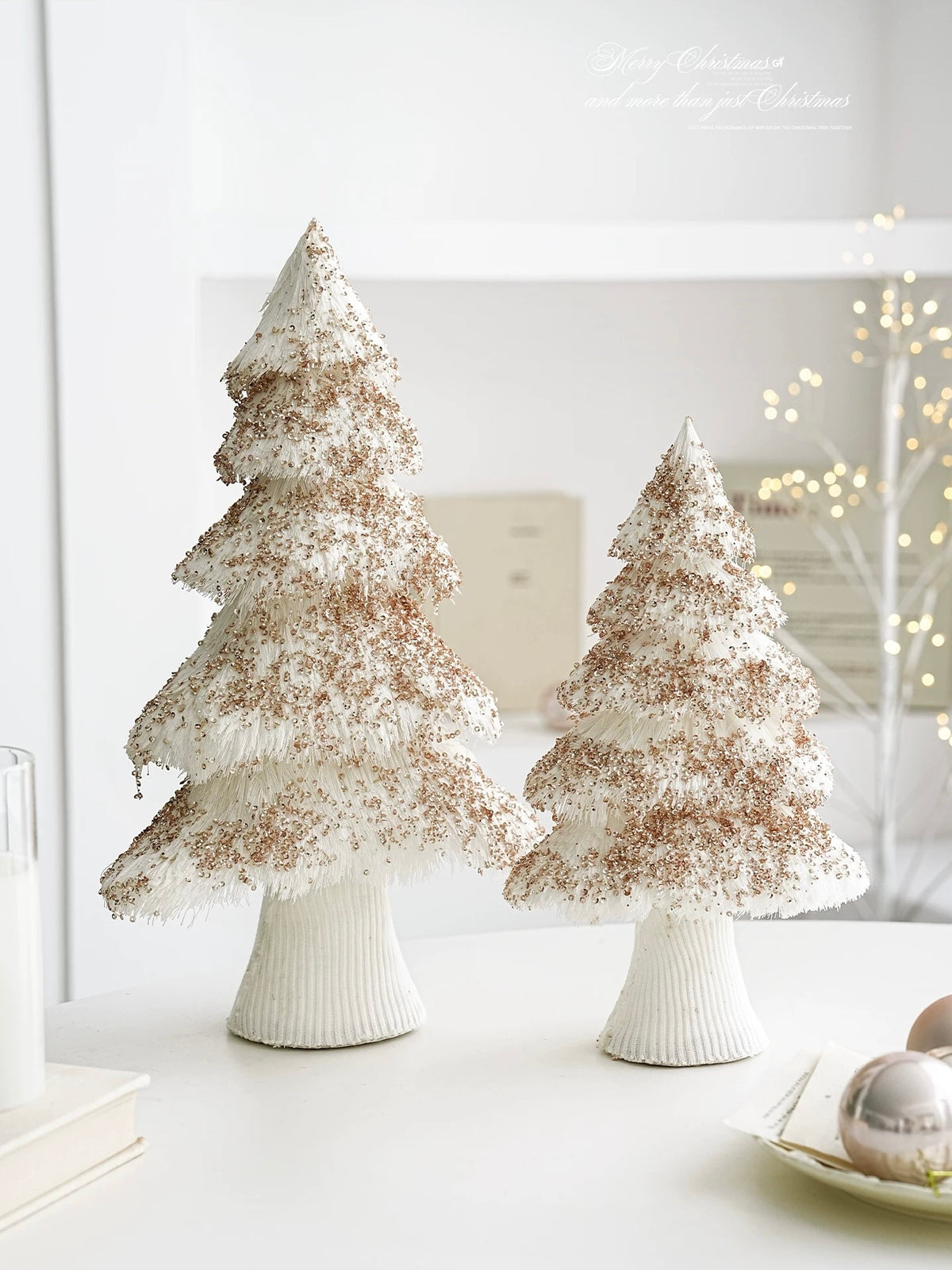 White yarn Christmas tree decorations stand together at different heights, with their wrapped bases visible.