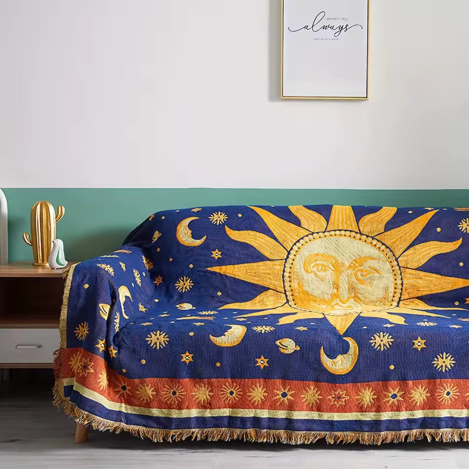 Decorative blanket with sun and moon design on a couch in a room.