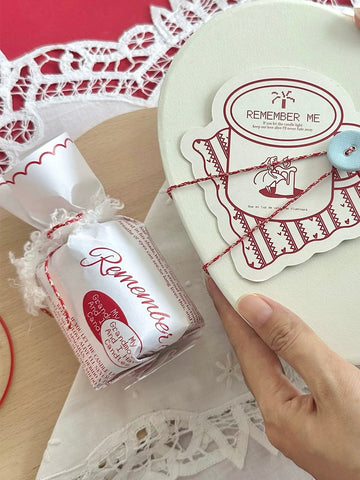 Wrapped Christmas scented candle held beside its gift packaging