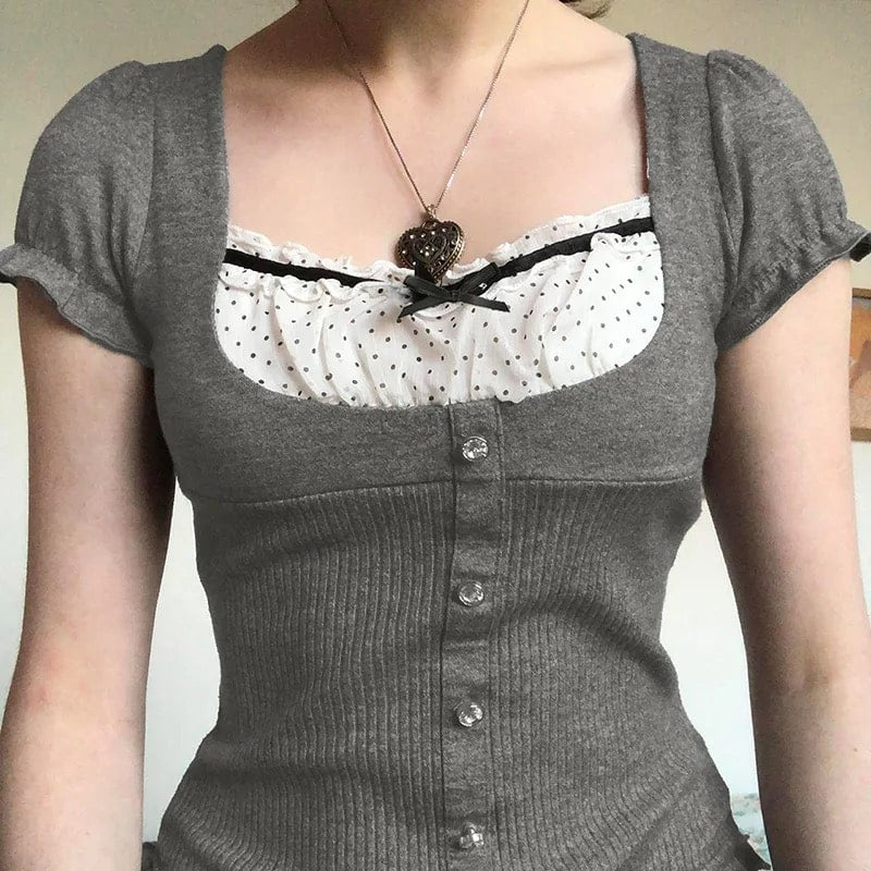 Y2K patchwork T-shirt with coquette ribbons and bow accents. Gray vintage crop top with puff sleeves and ruffle hem for retro aesthetic.