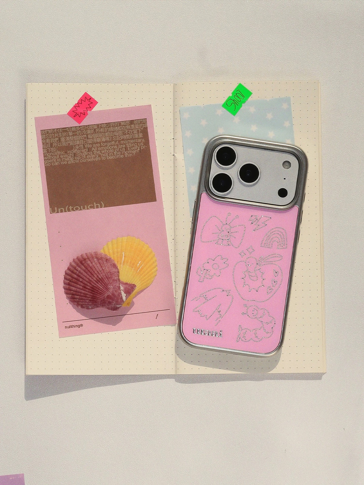 A Y2K phone case in pink, shown upright with silver outline drawings and a large camera opening.
