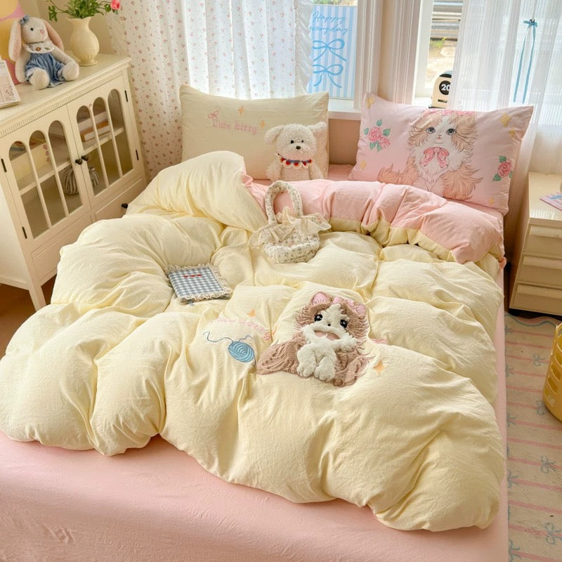 Bed with yellow comforter and pink pillows featuring cartoon dog designs in a bright room.