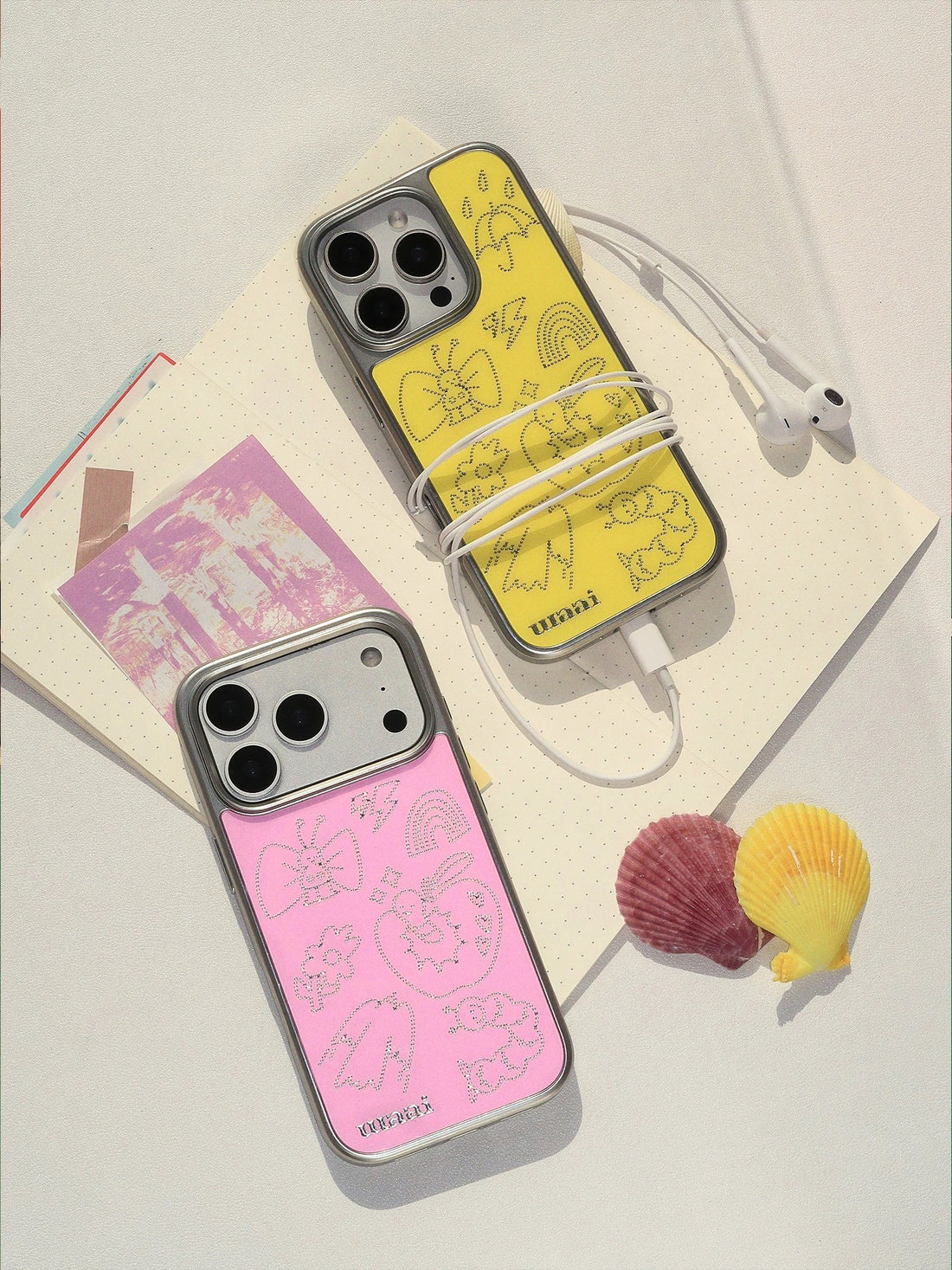 A doodle phone case in pink with fine silver butterfly, apple and candy outlines across the back.