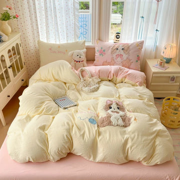 Bed with cartoon-themed bedding and pillows in a bright room.
